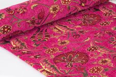 a close up of a pink and gold floral design on a plain fabric with white background