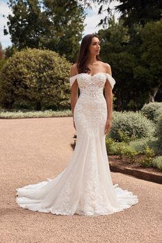 a woman in a wedding dress standing outside