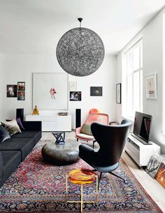 a living room filled with furniture and a large rug on the floor in front of a window