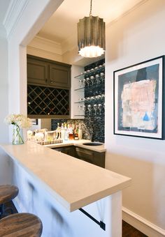 a kitchen with a white counter top next to a wine rack