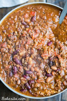 a pot filled with chili and beans on top of a wooden table