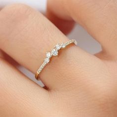 a woman's hand with a diamond ring on top of her finger and the band is