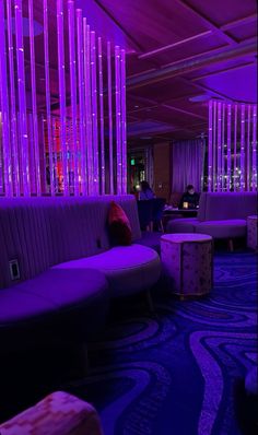 a room with purple lighting and couches