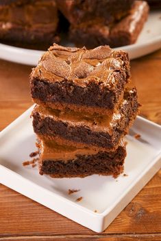 three pieces of chocolate cake sitting on top of a white plate next to each other