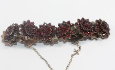 A decorative Antique Austro Hungarian Bohemian Garnet Bracelet in low carat gold which was made circa 1880. It is composed of graded clusters of garnets all around in 11 Flowers .  Box clip works well ,comes with safety chain.  16cms length x 2cms Luxury Garnet Jewelry With Intricate Design, Luxury Vintage Garnet Jewelry, Ornate Garnet Filigree Jewelry, Vintage Multi-stone Garnet Jewelry, Antique Hallmarked Garnet Jewelry, Austro Hungarian, Garnet Bracelet, Safety Chain, Gold Flowers