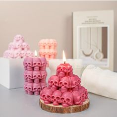 three candles with skulls on them sitting next to each other in front of a white box