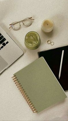 an open laptop computer sitting on top of a desk next to a notebook and pen