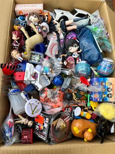 an open cardboard box filled with anime figurines