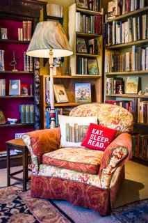 a living room filled with lots of furniture and bookshelves full of books on shelves