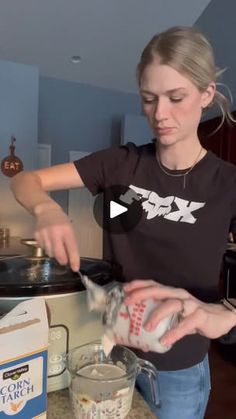 a woman pouring milk into a blender in a kitchen next to an open crock pot