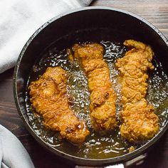 some fried meat is cooking in a skillet