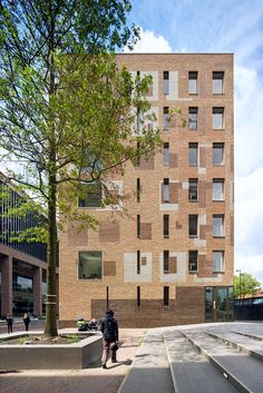 the building is made out of bricks and has many windows on each side, along with steps leading up to it