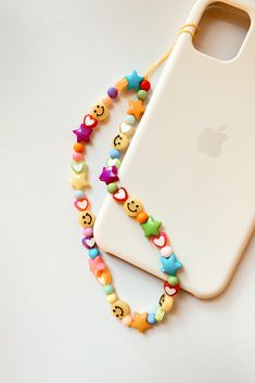 an iphone case with colorful beads and smiley faces on it