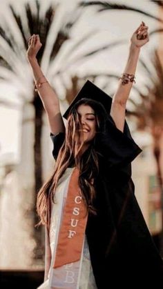 a woman wearing a graduation cap and gown with her arms in the air