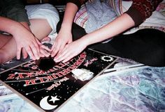 two people reaching for something on top of a bed