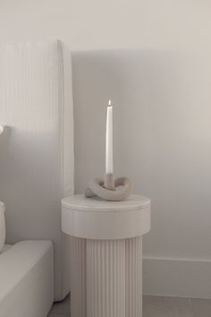 a white candle sitting on top of a table