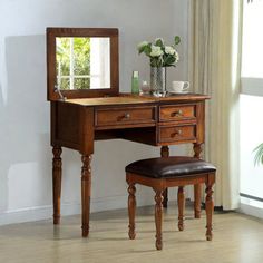 a wooden desk with a mirror, stool and potted plant on top of it