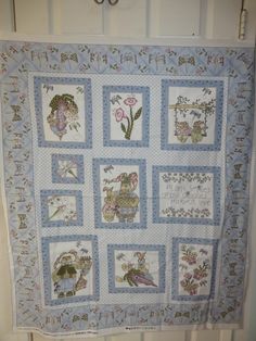 a blue and white quilt hanging on the wall