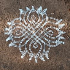 an intricate design on the ground with white paint and lines drawn in it to form a flower