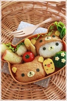 a bento box filled with food on top of a wicker basket next to a fork