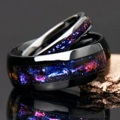 two black rings with purple and blue speckles sitting on top of each other