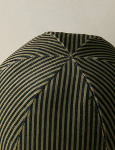 an umbrella with black and white stripes on the top is shown in front of a white wall