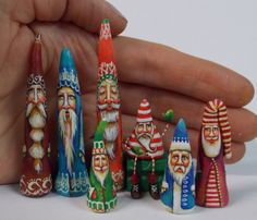 a hand holding a small group of colorful christmas figurines