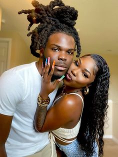 a man and woman hugging each other with their hands on her face while they both have colorful nail polish