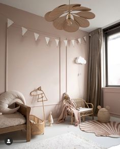 a room with pink walls and white furniture, including a wicker chair and fan hanging from the ceiling