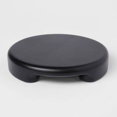 a black round object sitting on top of a white surface with no one around it