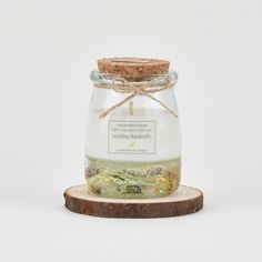 a jar filled with green tea sitting on top of a wooden slice