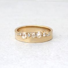 a gold ring with three stones on it sitting on top of a white countertop