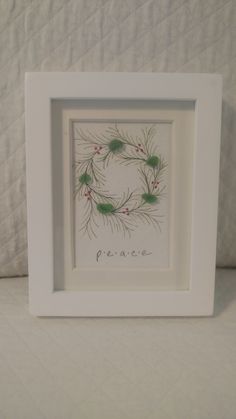 a white frame with a green wreath on it