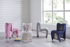 three chairs sitting next to each other on top of a hard wood floor in front of a window