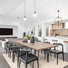 a dining room table and chairs in front of a kitchen