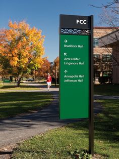 a sign in front of a building on the side of a road with trees around it