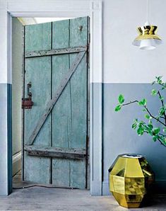 an open door leading into a room with blue walls and yellow vases on the floor