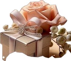 a pink rose sitting on top of a gift box