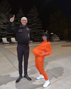 an older man and woman in orange outfits