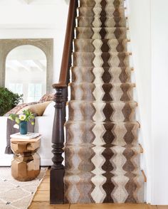 the stairs in this home are decorated with brown and white rugs