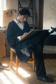 a man sitting in a chair reading a book