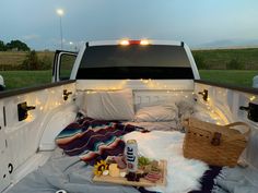 a bed in the back of a white truck with lights on it's sides