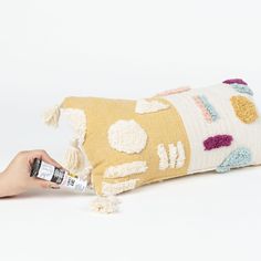 a person is holding a pillow that has been made with yarn and crochet