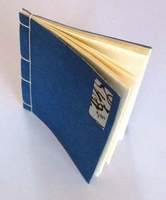 an open blue book sitting on top of a white table