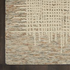 a brown and white rug on top of a wooden floor