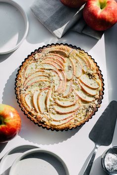 an apple pie on a table with plates and utensils