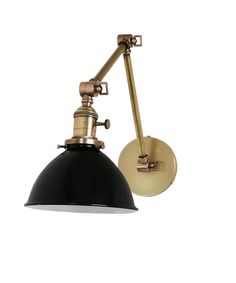 a black and gold wall light with a white shade on the side, against a white background