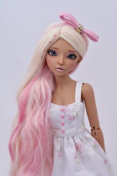 a doll with long pink hair wearing a white dress