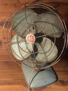 an old fan sitting on top of a wooden floor