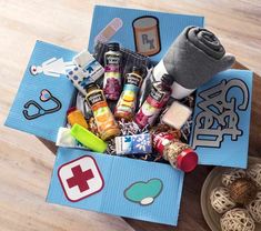 a box filled with lots of different items on top of a wooden floor next to bowls and spoons